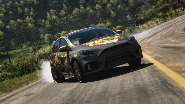 2017 Ford Focus RS with a grey wrap and Cheetos-branded livery drifting sideways around a turn and coming toward the camera.