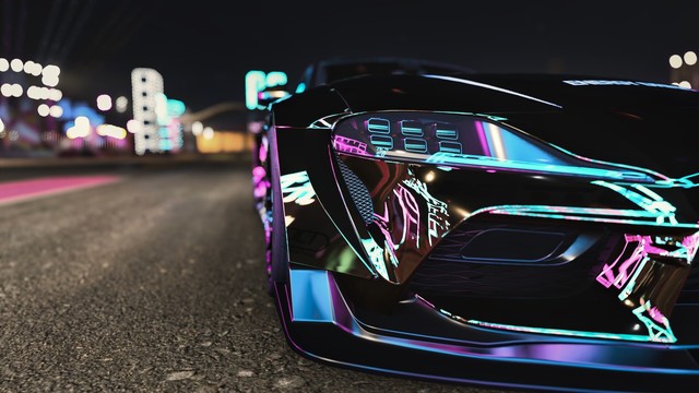 Close up of front left bumper and headlight assembly of a black and gold 2020 Toyota GR Supra reflecting magenta, cyan, and yellow neon slights with a blurred background.