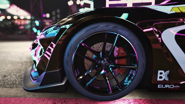 Close up shot of the front right wheel, black 5-spoke rim, bodykit, and bumper a black and gold 2020 Toyota GR Supra reflecting magenta, cyan, and yellow neon slights with a blurred background.
