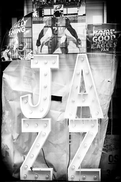 Black and white photograph of the word "jazz" in an abandoned storefront.