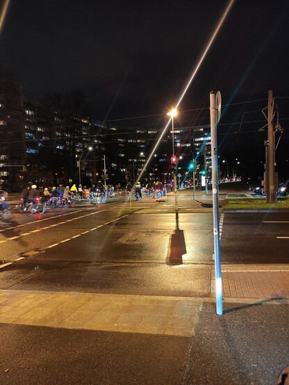 Zu sehen ist eine kritische Masse Fahrradfahrender auf der Straße "Platz der Vereinten Nationen" Richtung Friedenstraße. Mehrere hundert Räder sind zu sehen.