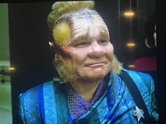 Neelix in a blue outfit and with an appreciative and emotion smile on his face.