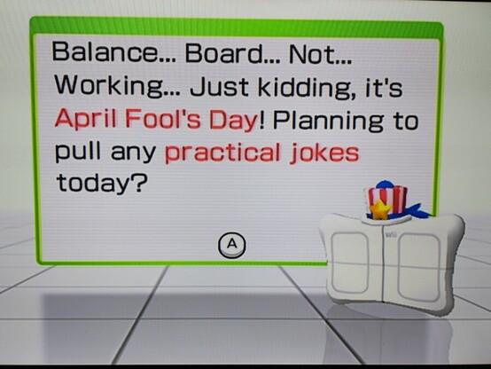 Screen cap of the Wii Fit balance board character saying, "Balance... Board... Not... Working... Just kidding, it's April Fool's Day! Planning to pull any practical jokes today?" For some reason it is wearing a red and white striped top hat with blue ribbons and a gold star.