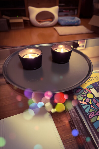 Two lit candles on a tray.