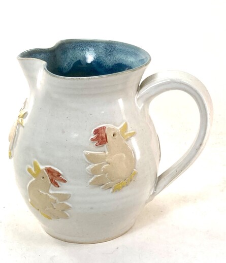 Ceramic pitcher with chickens in relief on the side