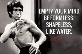 A photo of the legendary martial artist Bruce Lee ready to strike an opponent, with a legend that says: "Empty your mind. Be formless, shapeless, like water".