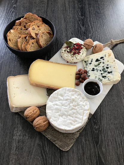 Un petit plateau de fromages français (camembert, bleu, comté, roquefort...) accompagné de pain et noix