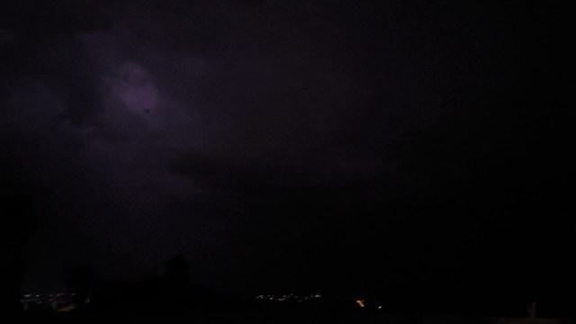Lightning display through storm clouds.