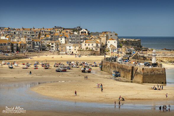 The pretty seaside town of St Ives in West Cornwall, pictured under blue skies and sunshine at low tide – summer at its best!
