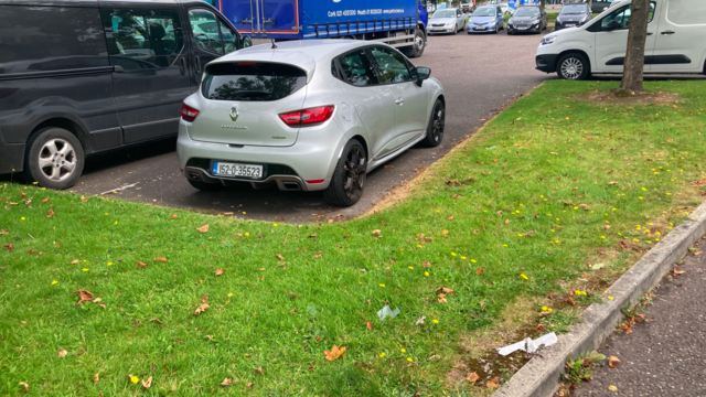 A silver hatchback in a car park