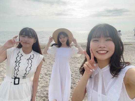 Shu Uchida, Maria Sashide, and Kito Akair selfie on the beach in their white dresses.