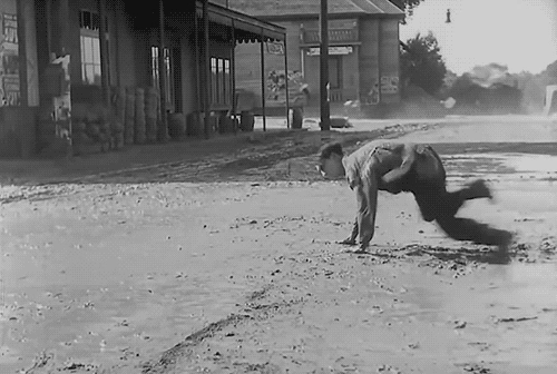 animated gif of silent movie comedy clip showing Buster Keaton struggling to walk forward in high winds