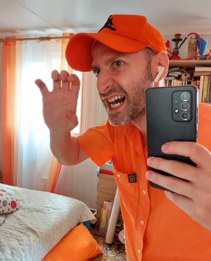 An orange vampire showing off his fangs and taking a selfie in the mirror because, in Eastern Europe, they do have a reflection.