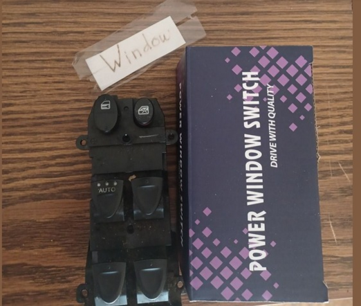 Picture of an extracted driver's side master window switch from a 2010 Honda Civic, the box the replacement part came in, and a little piece of paper with scotch tape that says "Window".