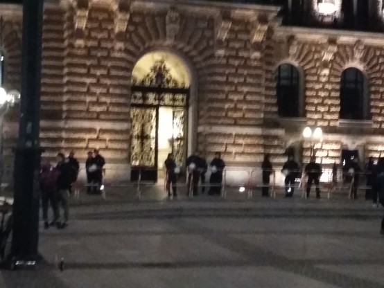 Erleuchteter Eingang des Hamburger Rathaus, davor Polizei, die eher gelangweilt rumstehen.

(Zu diesem Zeitpunkt 20:00, hatte der sog. Bürgerdialog der AFD schon begonnen, auf dem Vosgerau als Redner geladen war. Der Platz vorm Rathaus war gesperrt für Demos, mich haben sie mit meiner Pommestüte und als ältere Frau durchgelassen :-)))