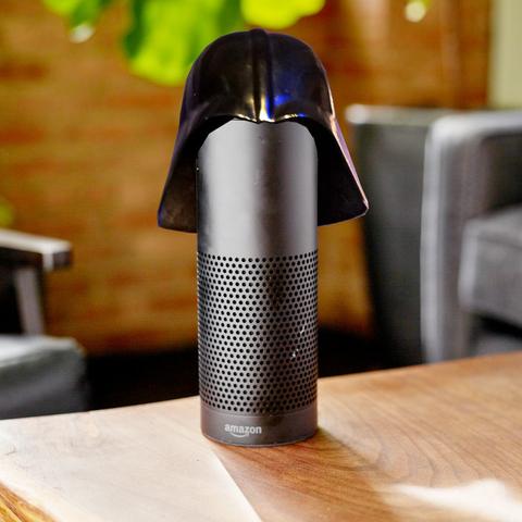 A cylindrical black Alexa speaker on a coffee table; it is wearing a Darth Vader helmet.

Image:
Stock Catalog/https://www.quotecatalog.com (modified)
https://commons.wikimedia.org/wiki/File:Alexa_%2840770465691%29.jpg

Sam Howzit (modified)
https://commons.wikimedia.org/wiki/File:SWC_6_-_Darth_Vader_Costume_(7865106344).jpg

CC BY 2.0
https://creativecommons.org/licenses/by/2.0/deed.en