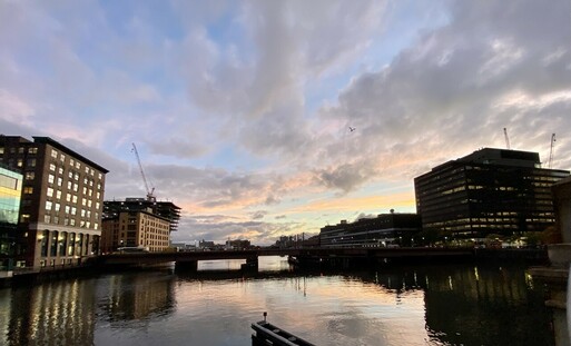 evening sky & buildings on either side of the channel of reflected in the water…even the red of the neon BOSTON WHARF sign is reflected 