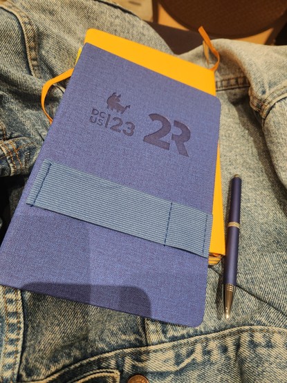 Blue notebook with the DCUS Bull logo and 2R logo.