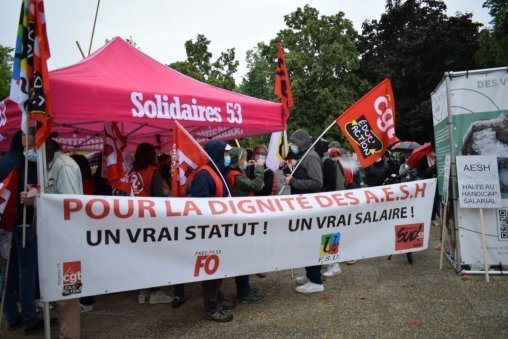 Stand Solidaires 53 (Mayenne) sous un barnum rose siglé, devant une banderole de l'intersyndicale en majuscules rouges Pour la dignité des AESH, un vrai statut, un vrai salaire !