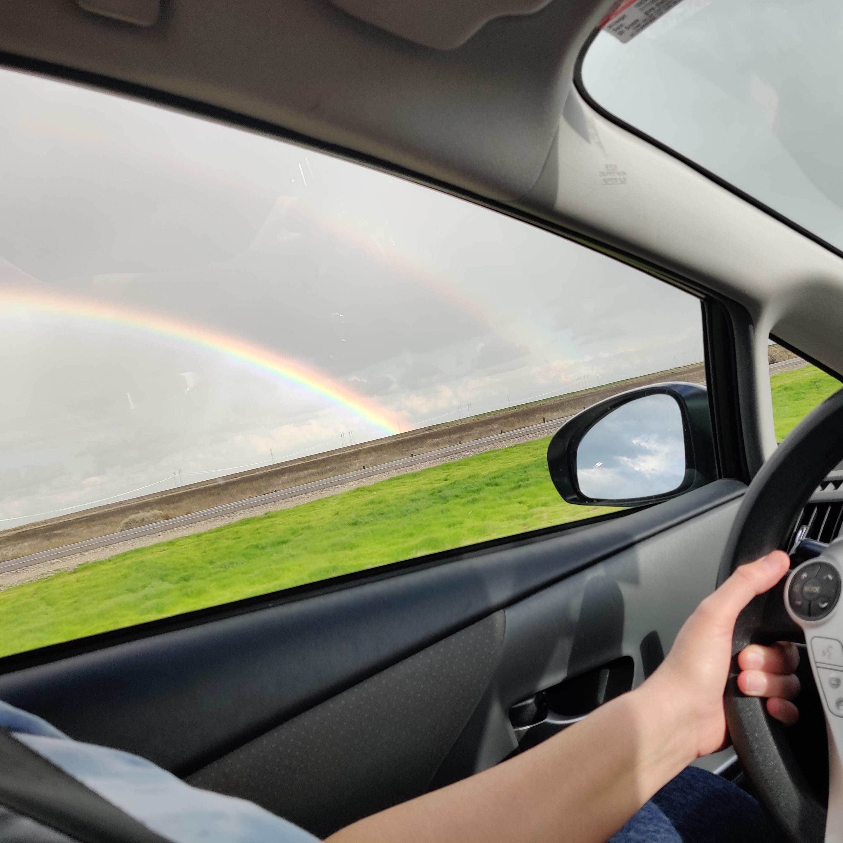 Double rainbow arc. Photo taken from passenger seat or driver's window in California