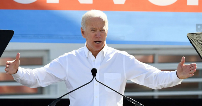 Joe Biden with his arms extended out to his sides, hands spread far apart, as if indicating the size of something massive
