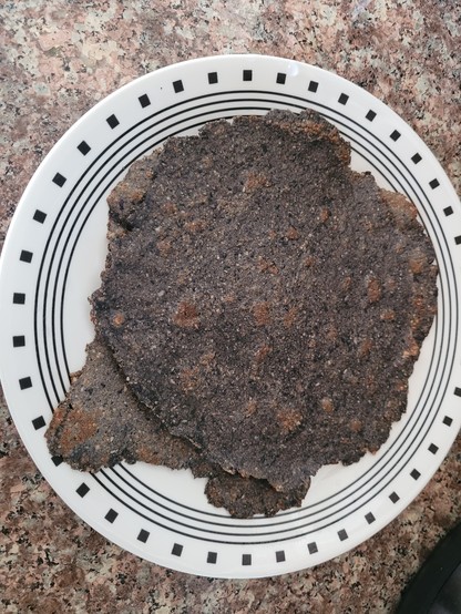 Black bean tortillas on a white Corelle plate. The black bean tortillas are quite blackish in color due to the use of homemade black tahini instead of brown tahini.