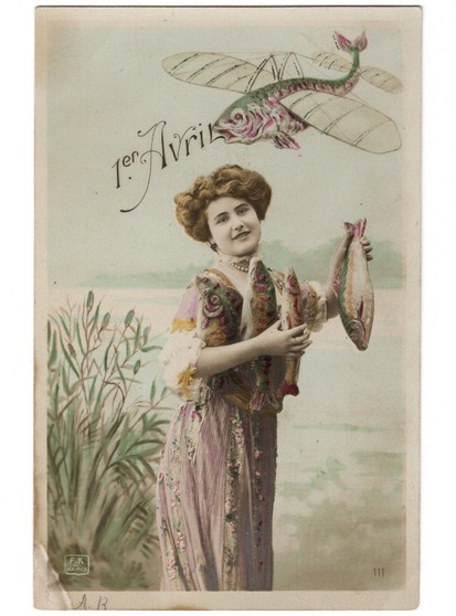 French postcard, c. 1905. Text "1er Avril" (April 1st). 

Image shows a woman standing beside a river holding 4 fish. Above her head another fish is flying, with wings like an early airplane. 