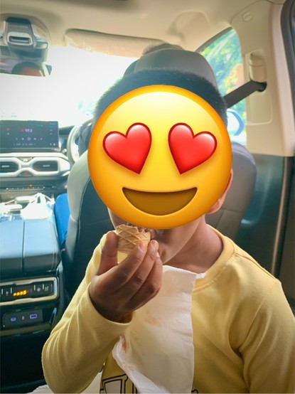 A little boy enjoying his McD softy cone in a car