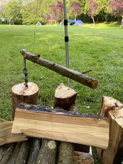 A log gets a center hole using a auger drill which uses a tree branch as its lever