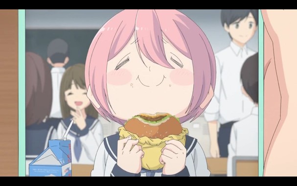 Imagen de Nadeshiko unos años atrás, más gordita y con el pelo corto, comiendo una hamburguesa en su aula de clase con su eterna cara de felicidad.