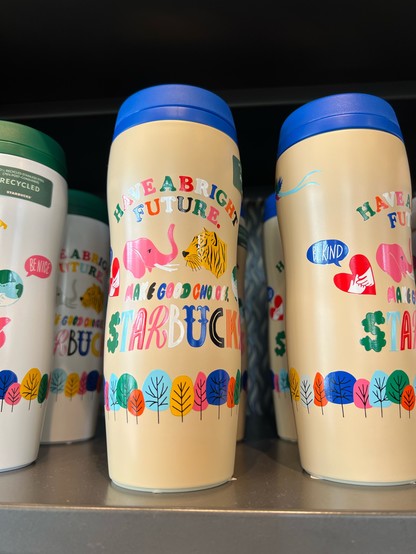 A Starbucks drink flask, brightly decorated with trees, an elephant and tiger, with the slogan “have a bright future. Make good choices.”