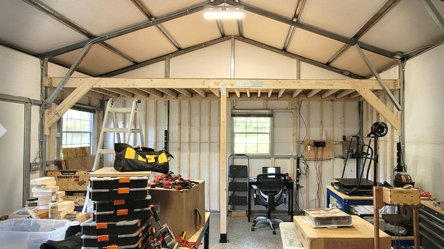 A picture of a custom storage loft built inside of metal-framed building. The maker finds it to be a nice blend of ferrous and timber construction.