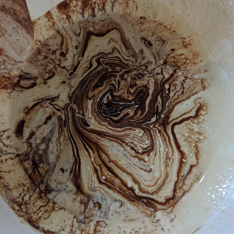 Brown batter mixing with white batter and making cool patterns.