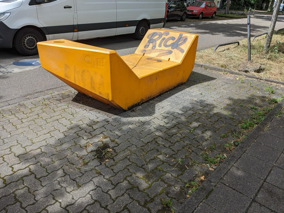 Gelbe Bank aus Plastik, mit Graffiti beschmiert 