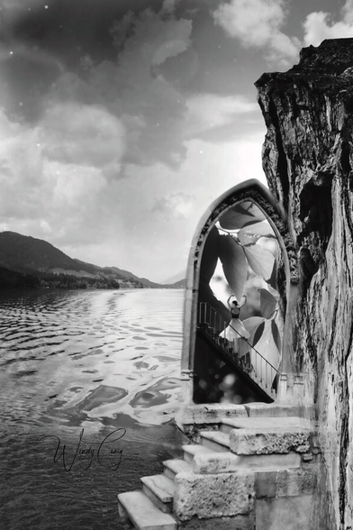 A surreal black and white photograph merges the side of a rocky cliff with a gothic-style arched doorway, opening to reveal an impossible scene of a large staircase and a person ascending. The reflection of the sky and clouds on the water's surface gives the lake a dreamy appearance, enhancing the ethereal quality of the photo.