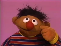 Photo of Ernie (of Bert & Ernie from the Muppets) scratching his head & looking puzzled.