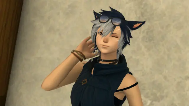 A blue-haired miqo'te, standing in front of a wall and winking at the camera. This shot is with pre-Dawntrail graphics.