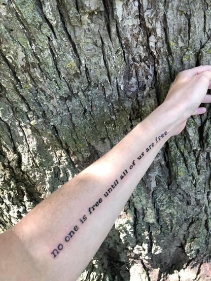 Forearm with new tattoo: “no one is free until all of us are free.”
