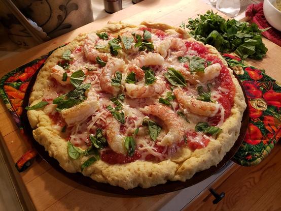 Shrimp and basil pizza on a cutting board. Uncooked