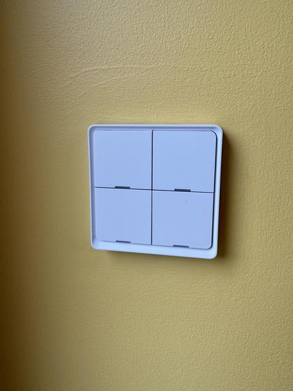 A Moes 4 button switch on a yellow wall