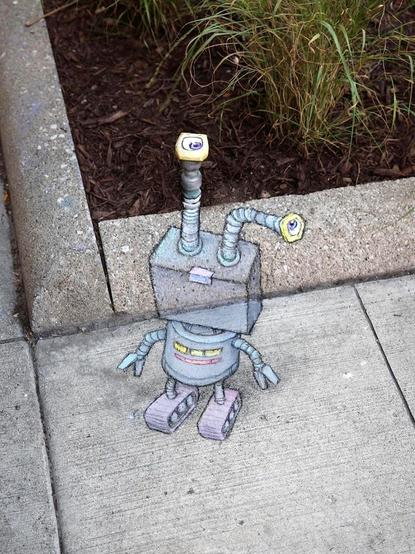 Streetart. A small, gray robot (named Caleb) with a 3D effect was painted with chalk between the plant bed and the sidewalk. The little robot has a square head, a can-like body, gripper arms and elongated roller feet. The most striking feature, however, are its two large eyes, which are attached to long metal links pointing upwards and to the side. A water valve with a square valve head, which is sunk into the plant bed, has also been integrated as an eye. Now it stands somewhat lost in the area.