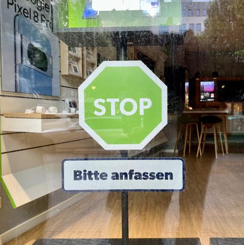 Green stop sign in a window