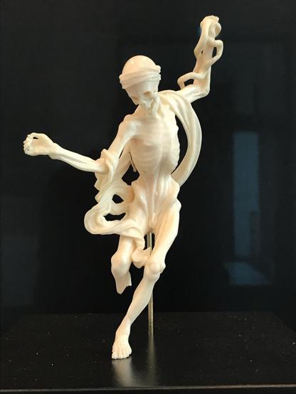 ivory carving of dancing death (Totentanz) skeleton with ribbon of cloth wrapped around it
