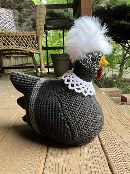 A black and white @SCOTUS knitted chicken with white furry pompadour and lace RBG collar