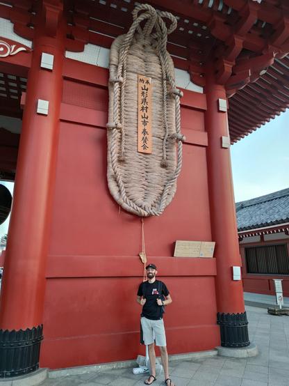 Me, standing under an Owaraji, a giant straw sandal that is meant to keep demons at bay. A special highlight for a sandal-runner. 😄
