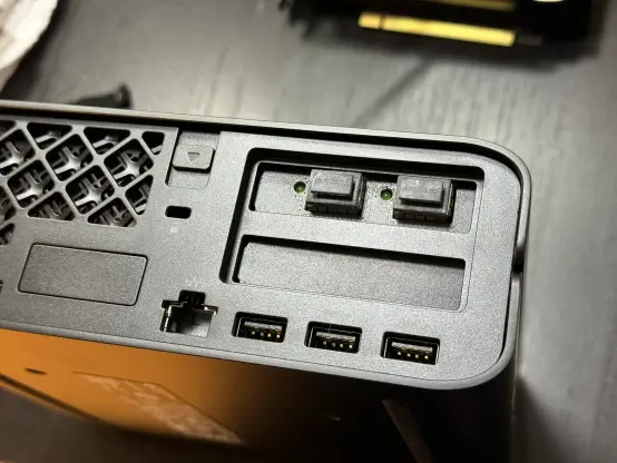 The backside of an HP Z2 Mini G9 with SFP+ ports coming out of a 3D printed bracket