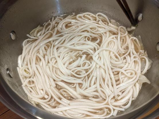 Udon simmering in a pot with just a bit of dashi