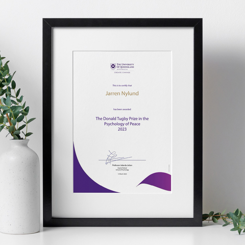 Image of a framed UQ certificate that says: “This is to certify that Jarren Nylund has been awarded The Donald Tugby Prize in the Psychology of Peace 2023, Professor Jolanda Jetten, Head of School, School of Psychology.”