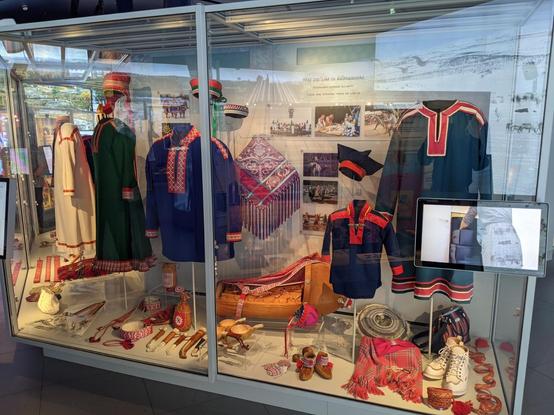 Une vitrine du musée Sámi d'Inari montrant des habits traditionnels colorés.