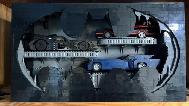 Photo of the Lego Batman Shadow box, modified to display the 1960s Batmobile, 1989 Burton Batmobile, and the animated series Batmobile.